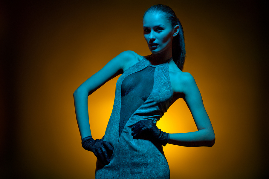 Glamorous image of fashion model in studio shot with colored gel